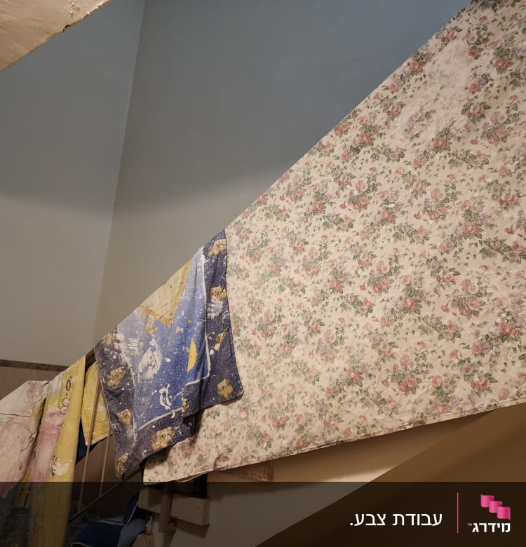 בדים צבעוניים תלויים על מעקה מדרגות